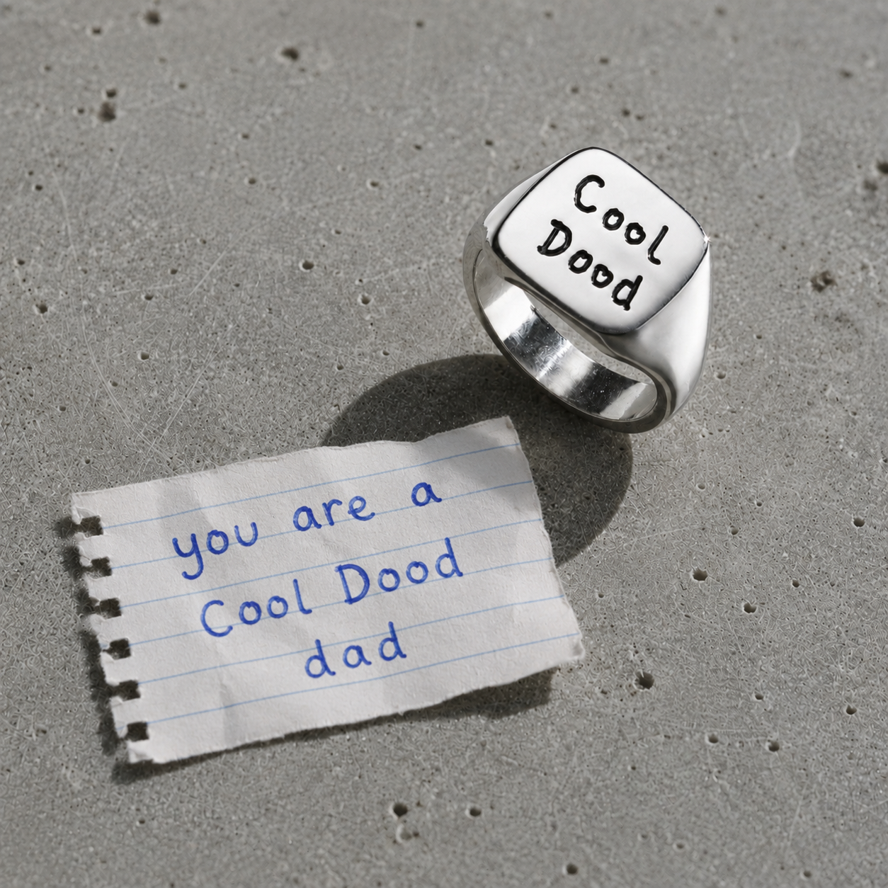 Men's handwriting square signet ring beside the original handwritten note
