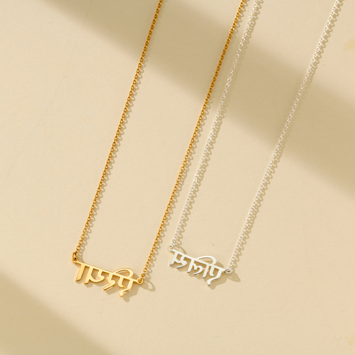 Silver and yellow gold plated Hindi name necklaces shown together