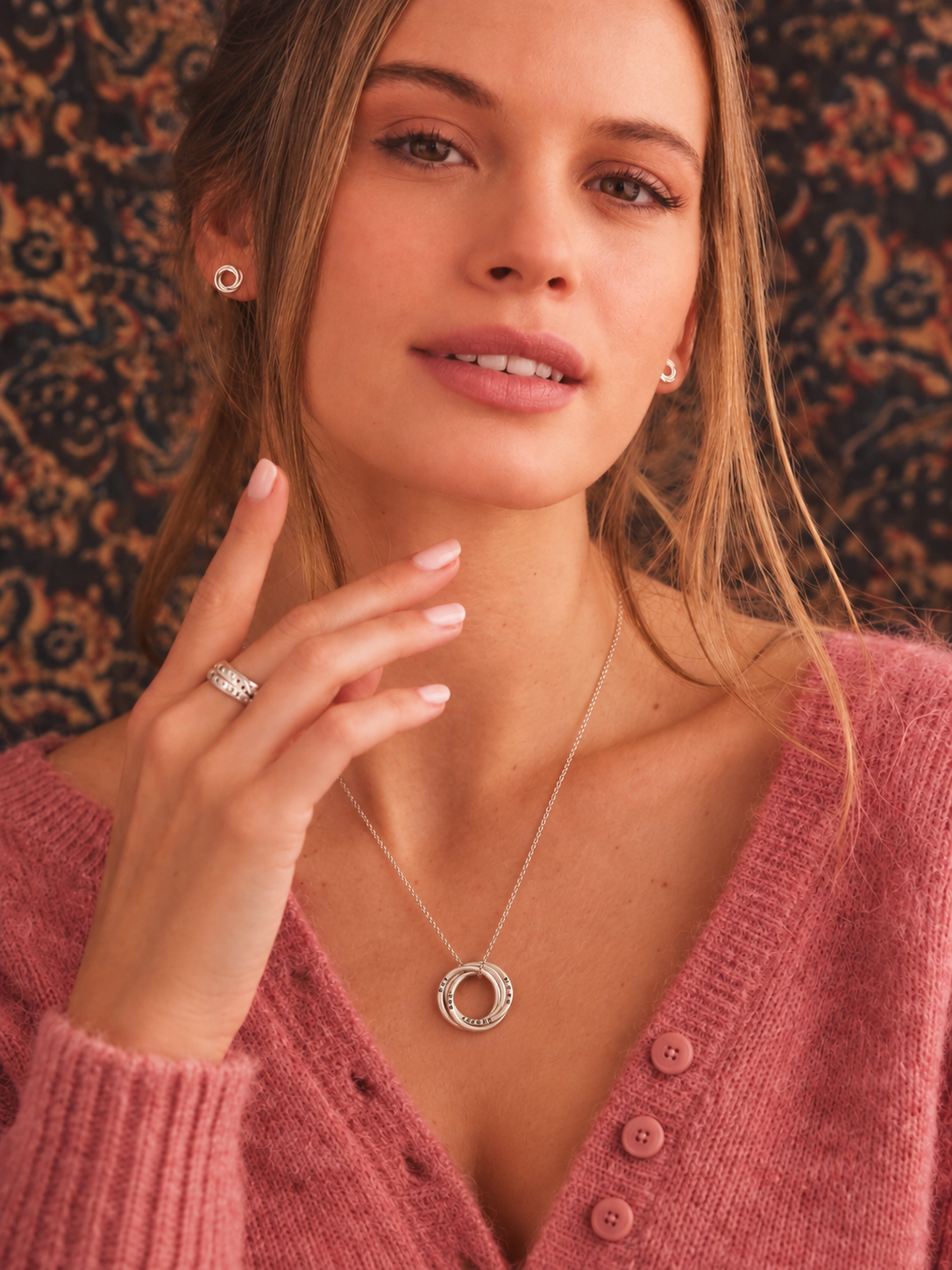 Silver personalised four ring Russian necklace worn with a pink cardigan
