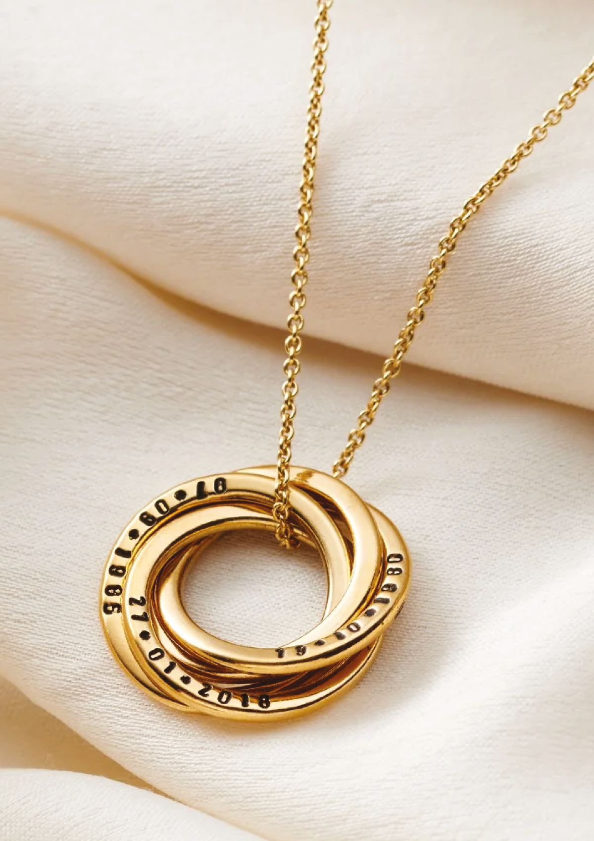 Gold personalised Russian ring necklace on cream fabric