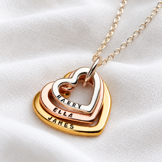 Mixed gold family names heart necklace on white linen