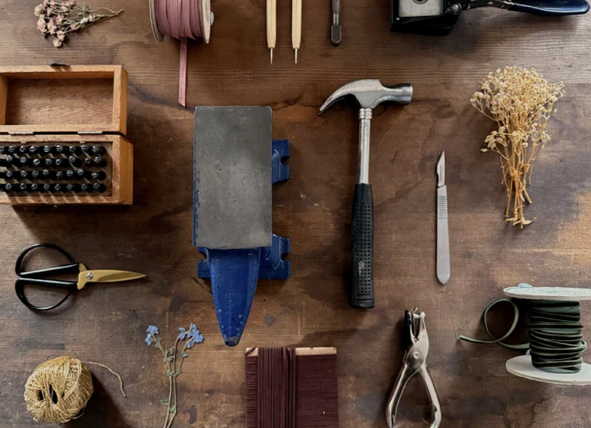 Jewellery making tools arranged on a wooden workbench